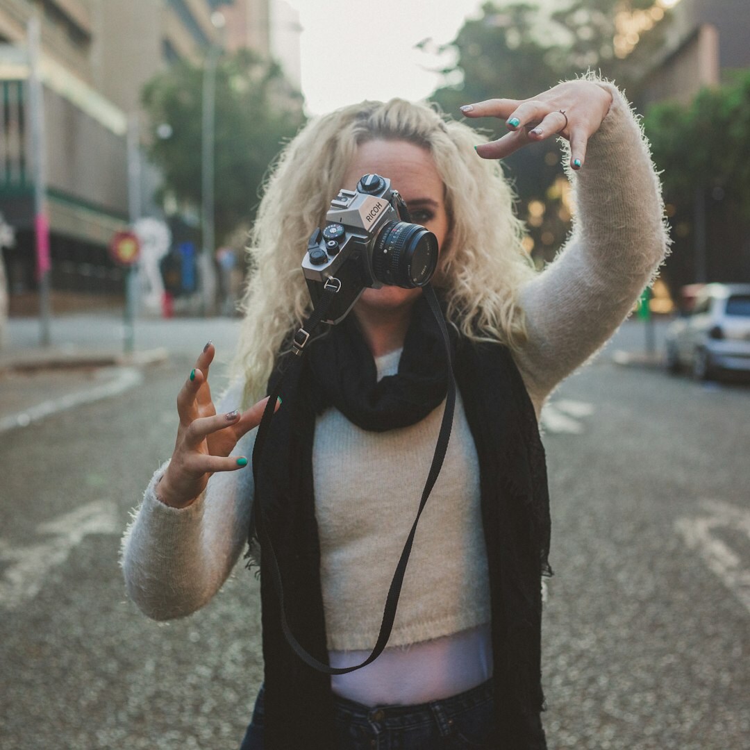 Young woman student holding a camera and smiling